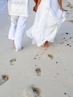 Wedding couple leaving footprints in the sand
